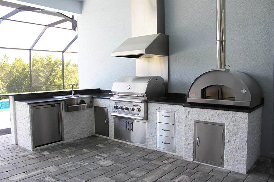 custom kitchen with stainless steel appliances and pizza oven